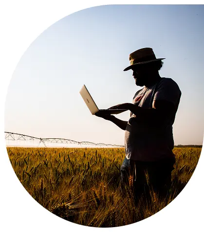 Imagem de um homem Homem usando notebook no campo